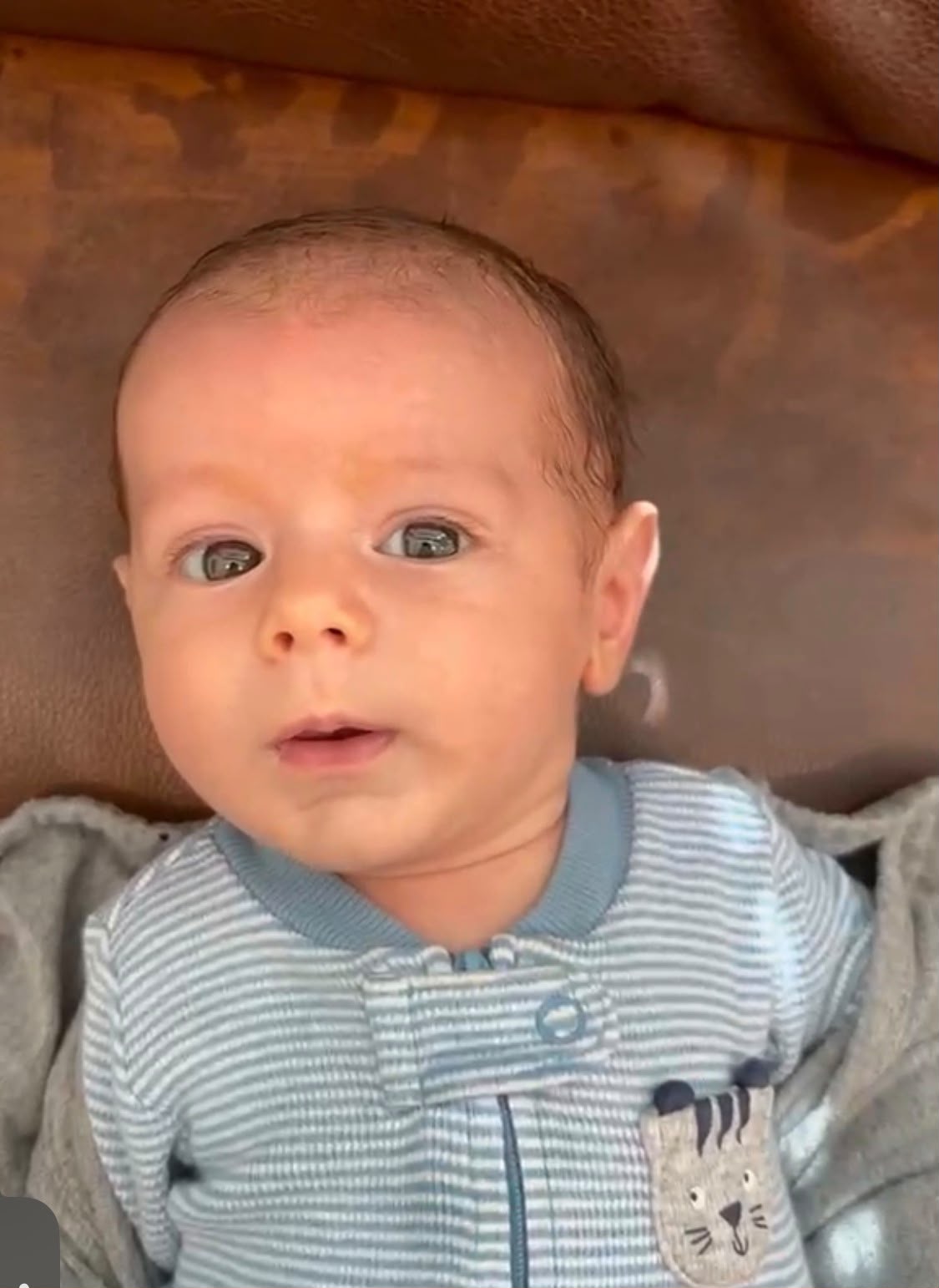 Baby Michael Moshe looking at the camera in a striped outfit