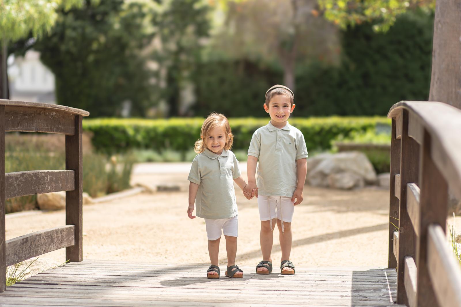 Daniel and Benayahu walking hand in hand on a bridge