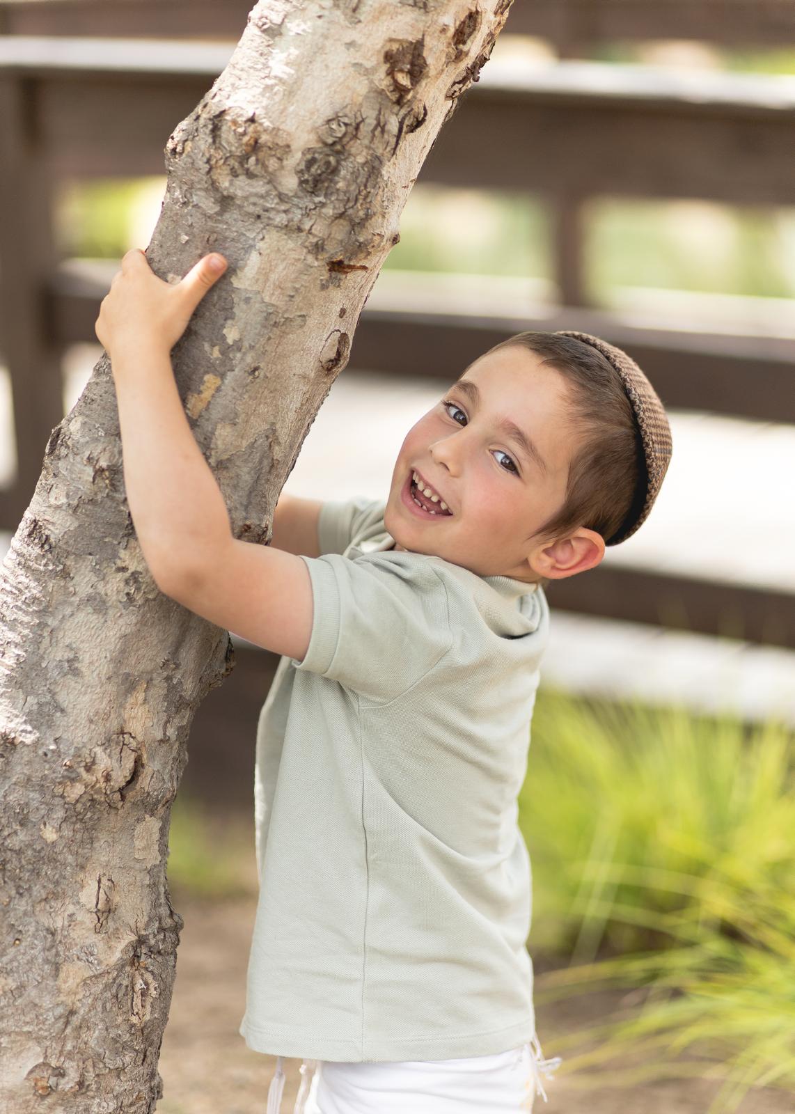 Shaul Benayahu holding onto a tree trunk